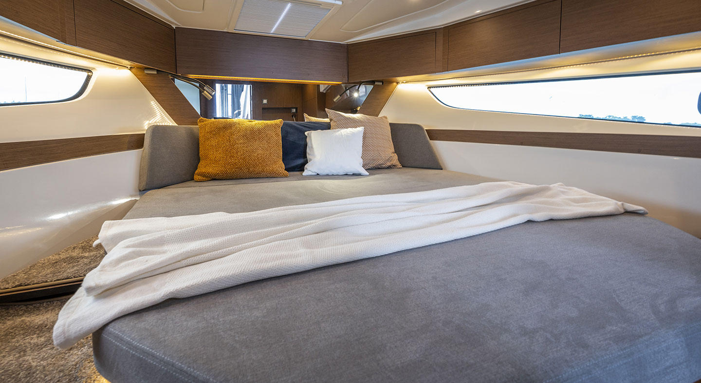 Antares 11 OB, photo de l'intérieur d'une cabine. Avec un couchage large et des fenêtre de chaque côté du bateau.