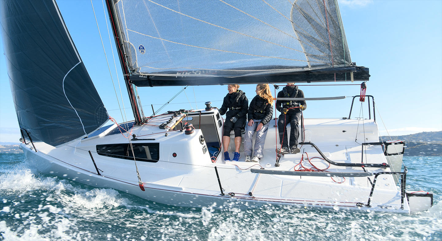 Photo du First 24 SE naviguant avec 4 personnes à son bord. Ses voiles sont déployées et elles ont une prise au vent.