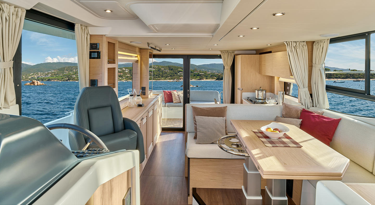 Intérieur du Swift Trawler 48. Il y a un espace de détente avec un banquette et une table pliante ainsi qu'une cuisine et de nombreux rangements. 