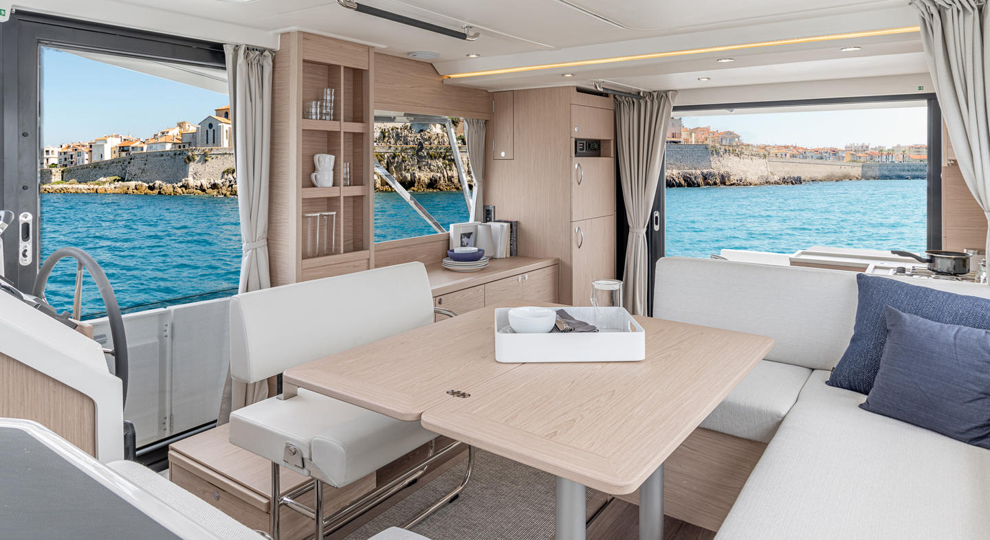 Intérieur du Swift Trawler 41 Fly. On aperçoit une banquette, une table et des rangements.